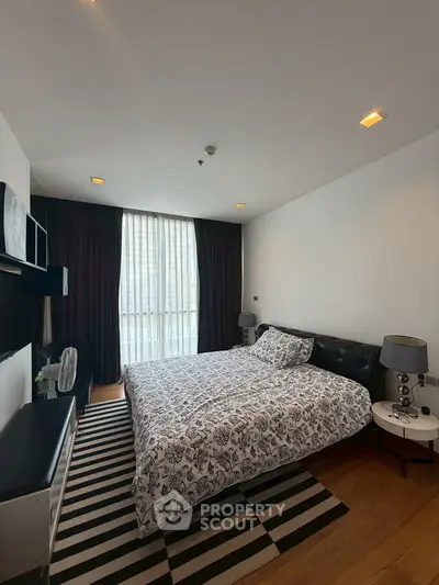 Spacious bedroom with modern decor and large window for natural light.