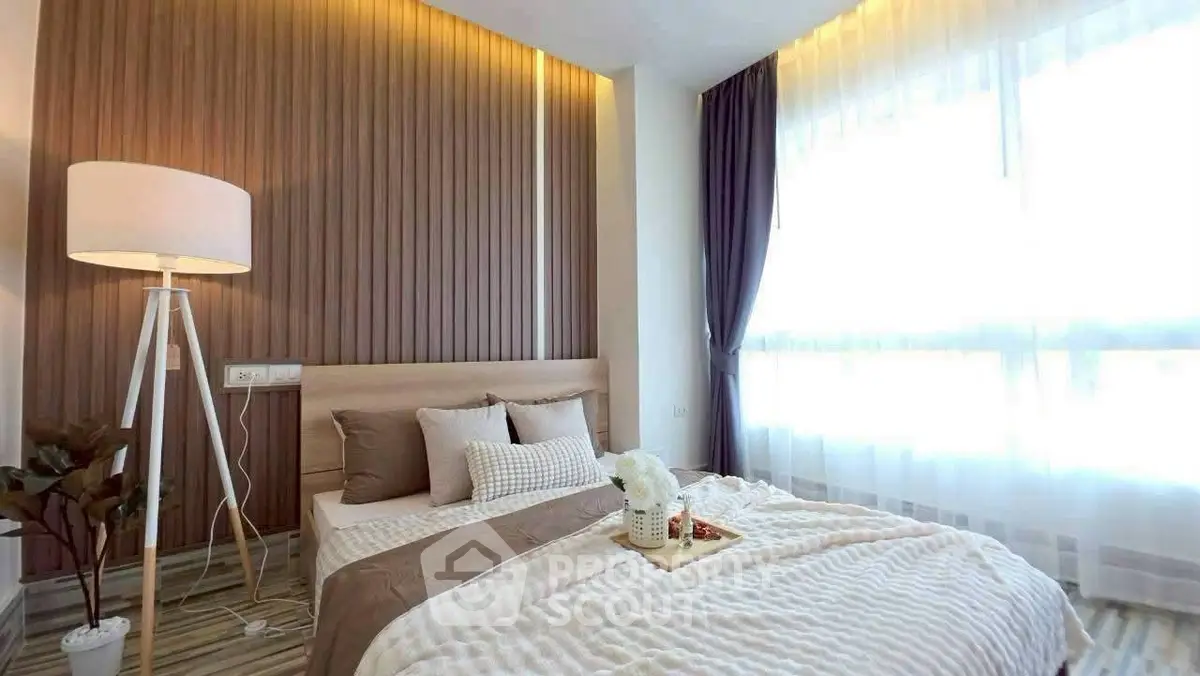 Modern bedroom with elegant decor and large window offering natural light
