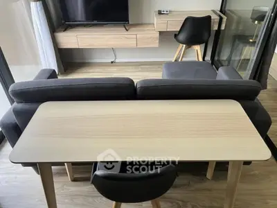 Modern living room with sleek furniture and wooden flooring, featuring a stylish TV setup and cozy seating area.