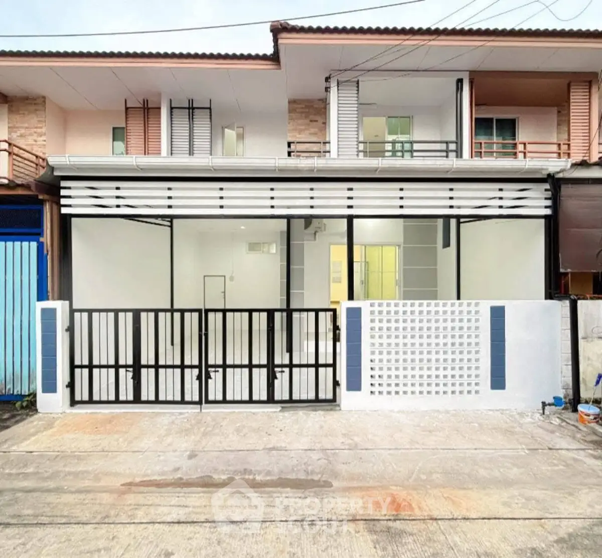 Modern townhouse exterior with sleek glass facade and gated entrance