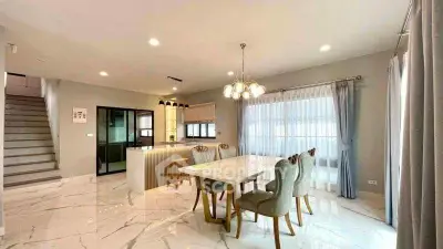 Elegant open-plan dining area with marble flooring and modern lighting in a spacious home.