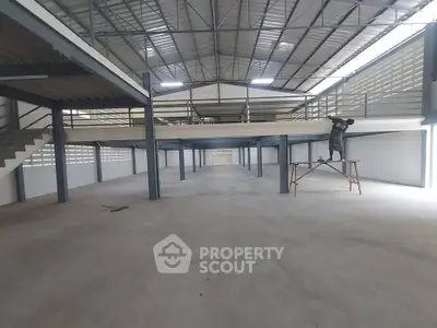 Spacious industrial warehouse with mezzanine and high ceilings, ideal for storage or manufacturing.