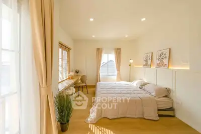 Bright and spacious bedroom with large windows and modern decor, perfect for relaxation and comfort.