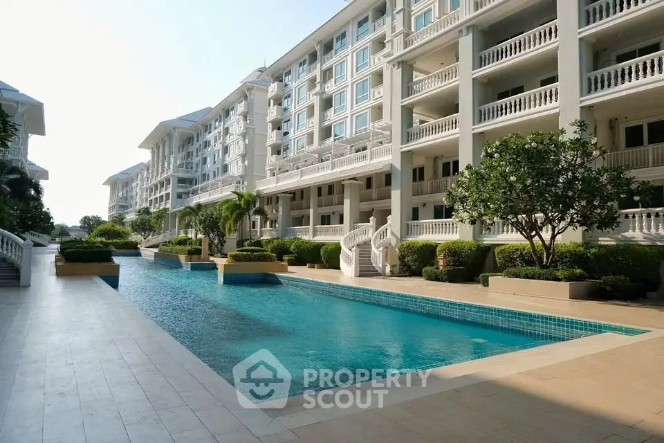 Luxurious apartment complex with stunning pool and lush greenery