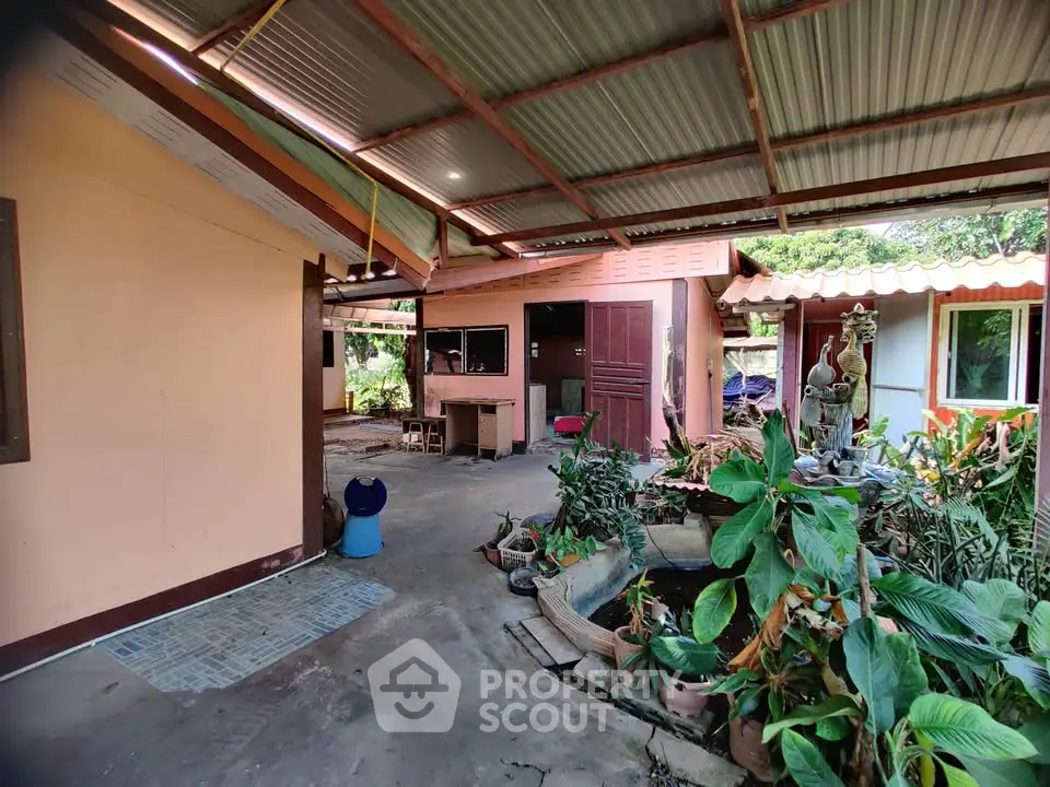 Charming outdoor garden area with lush greenery and rustic patio in a cozy home setting.