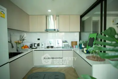 Modern kitchen with sleek cabinetry and appliances, featuring a cozy open layout and stylish decor.