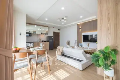 Bright and modern living room with open kitchen layout and stylish decor.