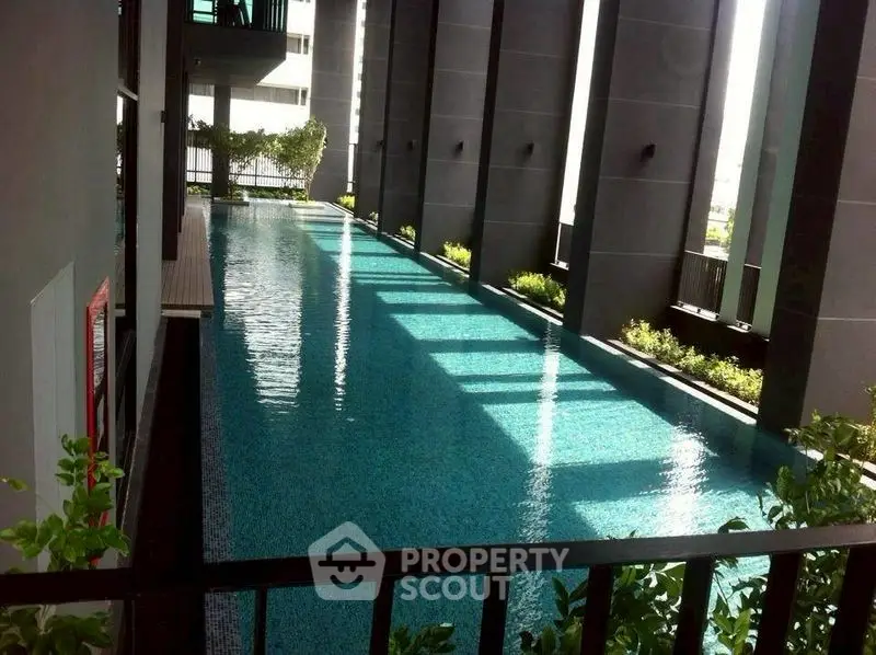 Luxurious indoor pool with modern architecture and lush greenery