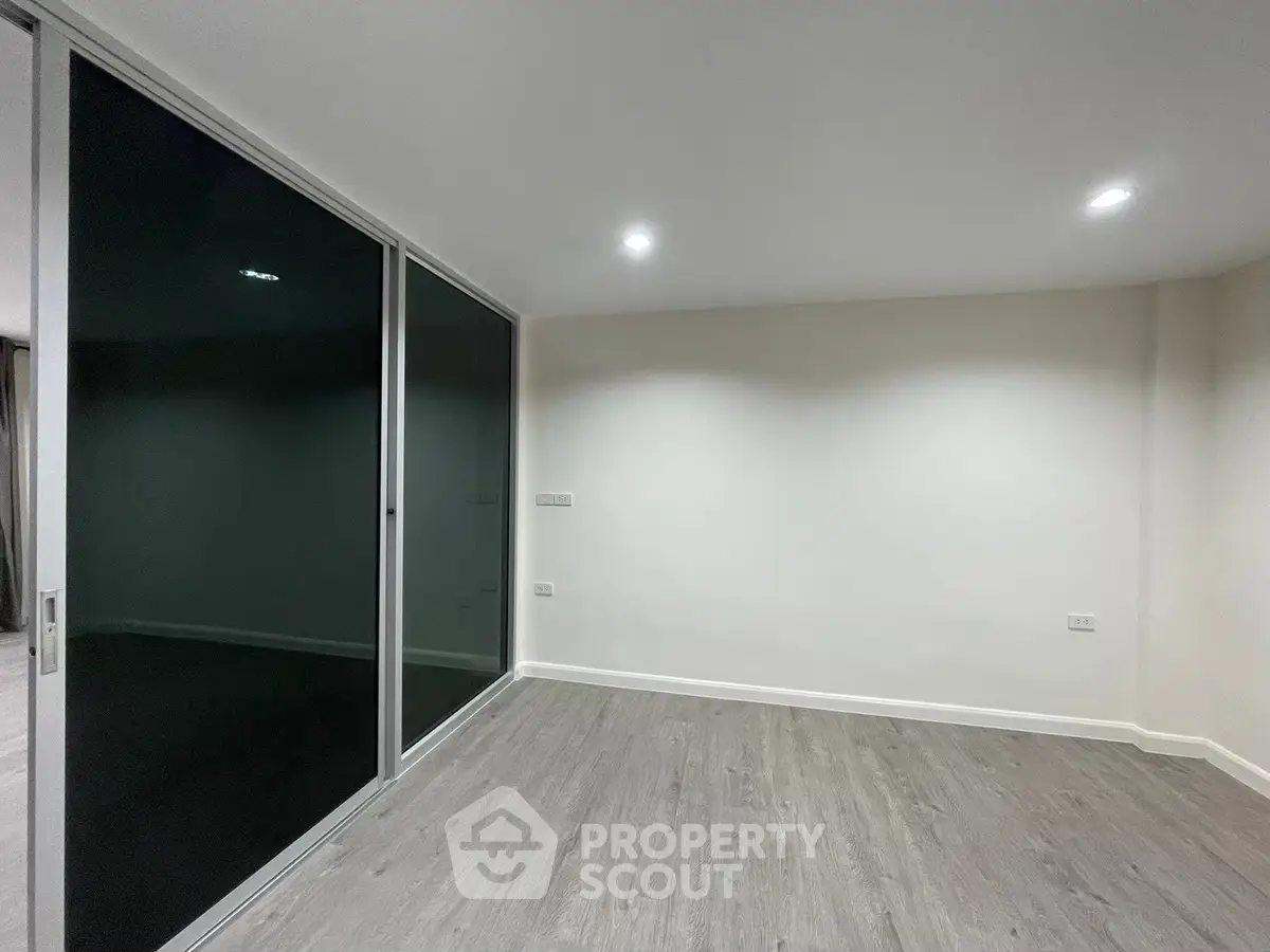 Spacious empty room with modern sliding glass doors and sleek flooring