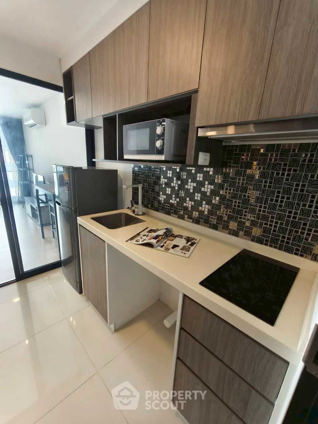 Modern kitchen with sleek cabinetry and mosaic backsplash in a stylish apartment.