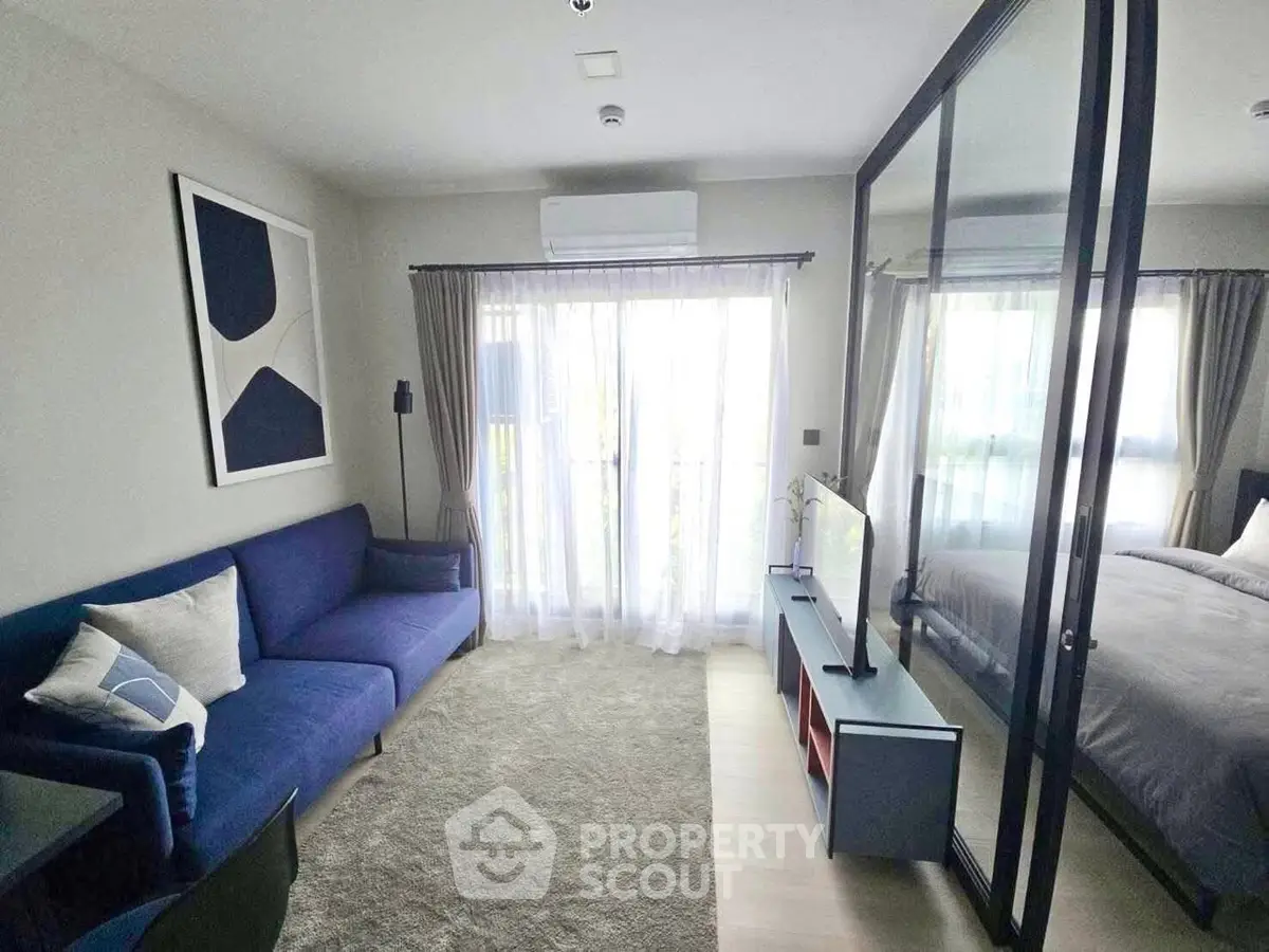 Modern living room with glass partition and cozy blue sofa