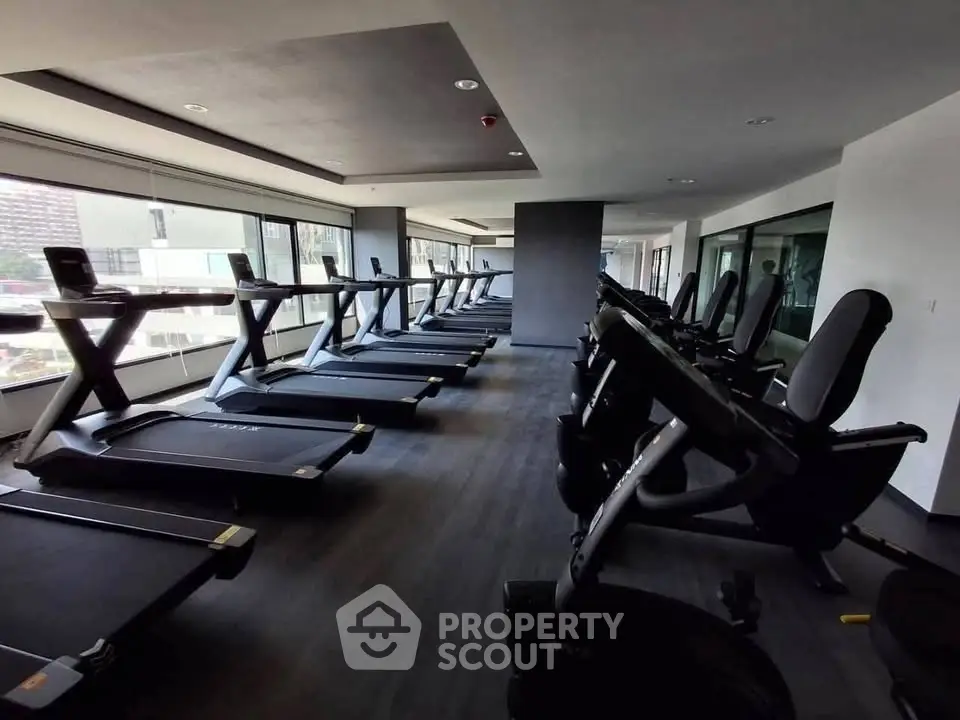 Modern gym with state-of-the-art equipment and panoramic city views, perfect for fitness enthusiasts.