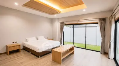 Spacious modern bedroom with large windows and wooden accents