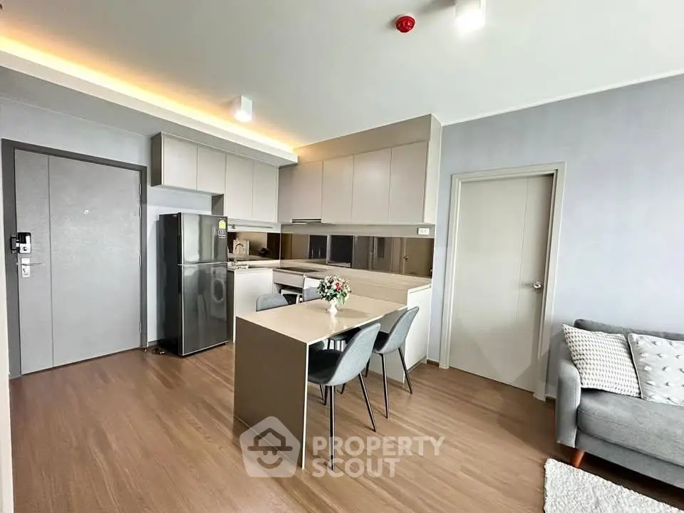 Modern open-layout kitchen and dining area with sleek design and contemporary furniture.
