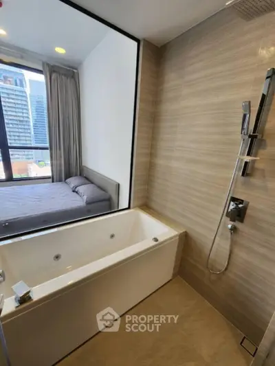 Modern bathroom with bathtub and view into stylish bedroom in urban apartment