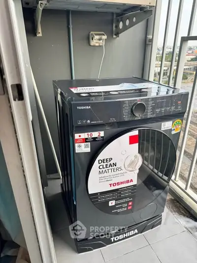 Modern washing machine on a balcony with city view, perfect for urban living convenience.