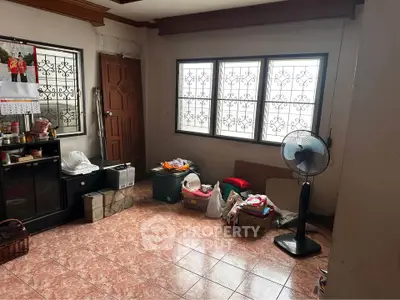 Spacious room with tiled floor, large windows, and ceiling fan, ideal for versatile living space.