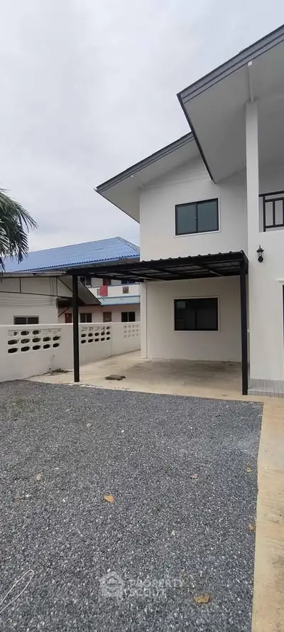 Modern two-story house with carport and gravel driveway