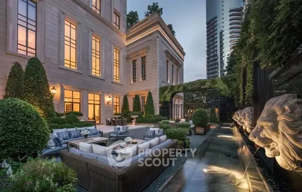 Luxurious outdoor garden with elegant seating and water feature in upscale residential building.