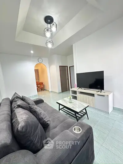 Modern living room with stylish sofa and TV, perfect for relaxation.