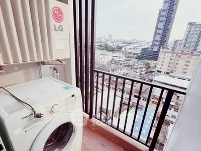 High-rise balcony with city view and washing machine, perfect for urban living.