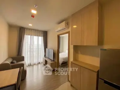 Modern apartment interior with open living room and kitchen, featuring sleek furniture and natural light.