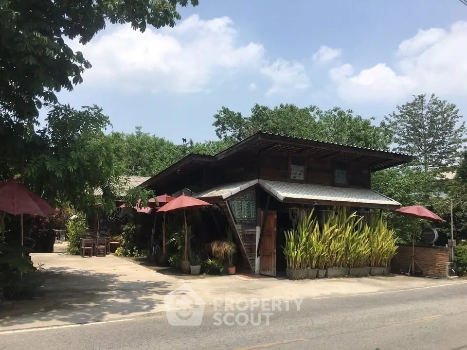 Charming rustic house with lush greenery and outdoor seating, perfect for nature lovers.