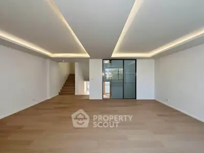 Spacious modern living room with wooden flooring and stylish ceiling lights