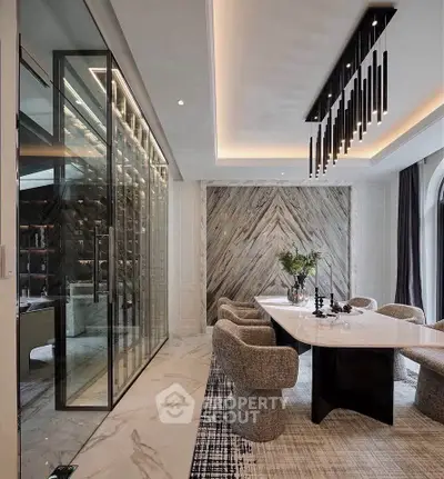 Luxurious dining room with modern chandelier and glass wine cellar, featuring elegant marble flooring and stylish decor.