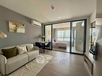 Modern open-plan living room with cozy seating and bedroom view