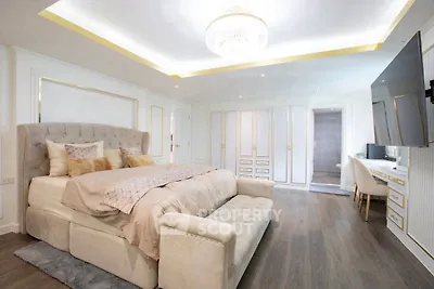 Luxurious bedroom with elegant decor, plush bed, and modern lighting in upscale home.