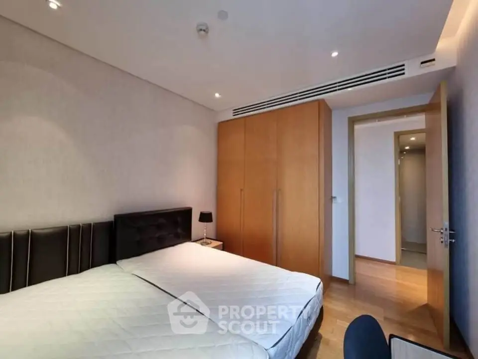 Spacious bedroom with modern design and ample natural light, featuring a large bed and built-in wardrobe.