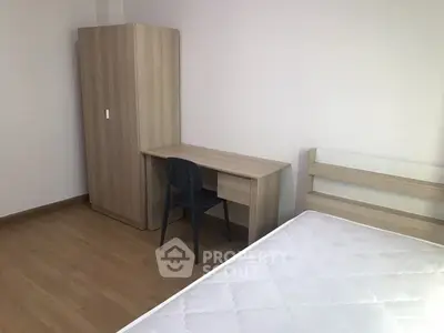 Minimalist bedroom with wooden furniture and a comfortable mattress, perfect for a cozy living space.