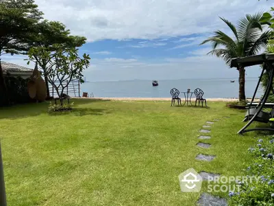 Stunning beachfront garden with ocean view and lush greenery, perfect for relaxation and outdoor activities.