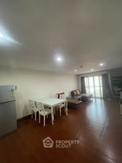 Spacious living room with modern furniture and natural light, perfect for relaxation and entertainment.