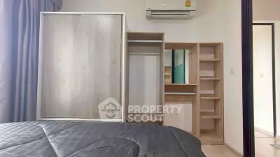 Modern bedroom with sleek wardrobe and air conditioning unit, perfect for comfortable living.