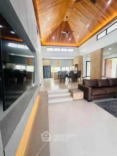 Luxurious open-plan living room with high wooden ceiling and modern decor