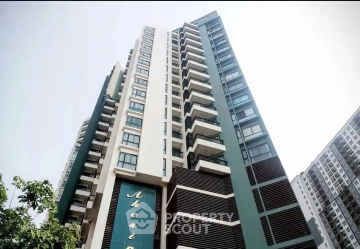 Modern high-rise building with sleek design and large windows in urban setting.