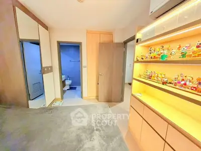 Cozy bedroom with built-in storage and colorful decor, featuring a glimpse into a modern bathroom.