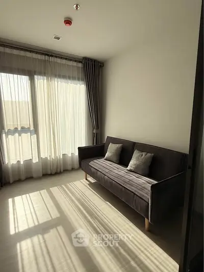 Bright living room with modern sofa and large windows in a stylish apartment.