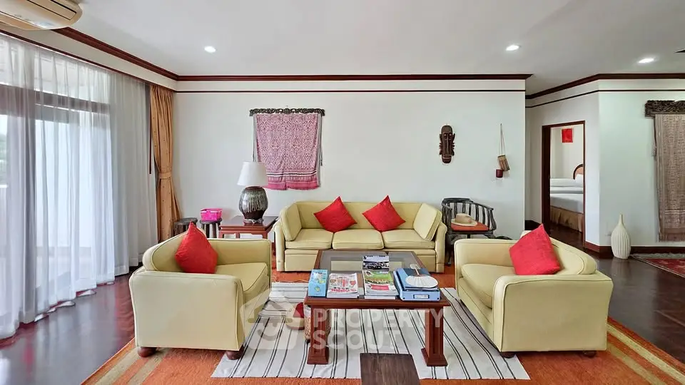 Spacious living room with elegant decor and natural light, featuring comfortable seating and stylish accents.