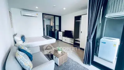 Modern studio apartment with cozy living area and compact kitchen, featuring air conditioning and washing machine.