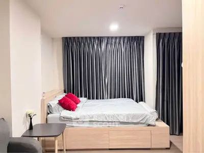 Modern bedroom with sleek design and cozy ambiance, featuring elegant curtains and stylish furniture.