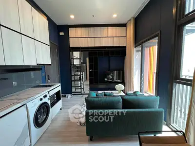 Modern living room with stylish furniture and integrated kitchen appliances in a chic apartment.
