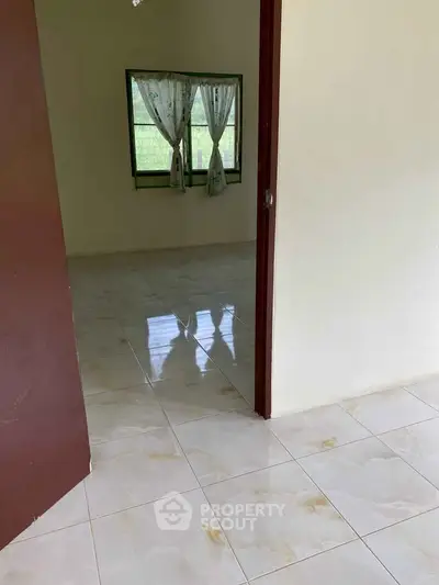 Spacious empty room with tiled flooring and window view