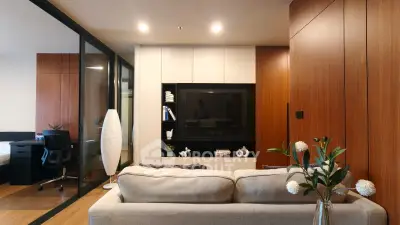 Modern living room with sleek wooden paneling and stylish decor, featuring a cozy sofa and elegant lighting.