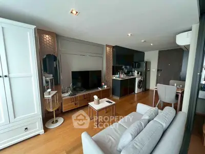 Modern living room with open kitchen, stylish decor, and wooden flooring in a cozy apartment.
