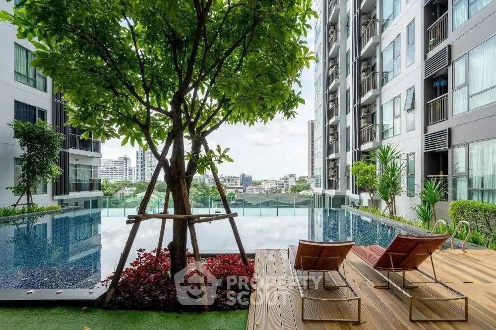 Luxurious apartment complex with serene pool and city view, perfect for relaxation and urban living.