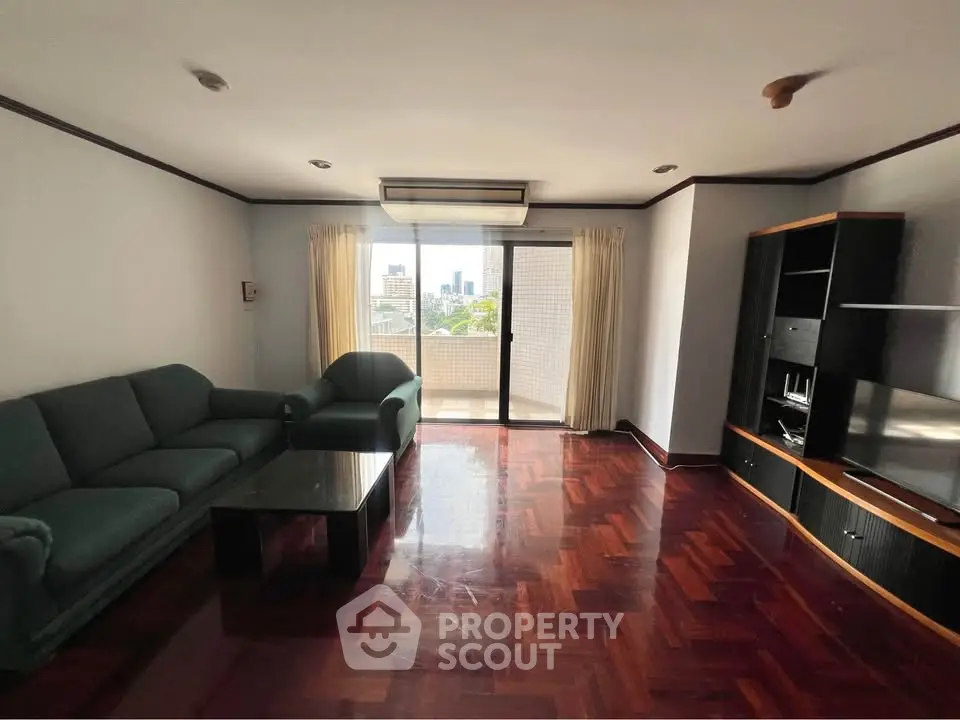 Spacious living room with elegant parquet flooring and large balcony view.