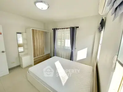 Bright and airy bedroom with modern furnishings and ample natural light.